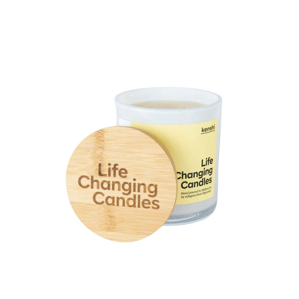 Candle with wooden lid labeled 'Life Changing Candles' on a white background