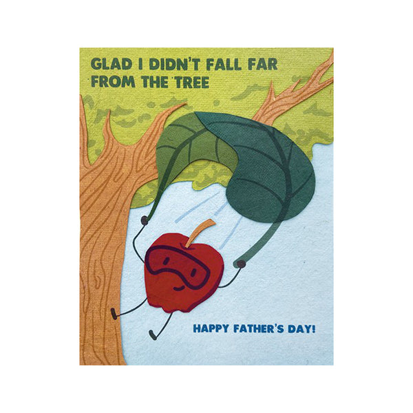 Fair Trade handmade card depicting a red apple with a leaf-shaped parachute near a tree. Message reads "Glad I didn't fall far from the tree. Happy Father's day"