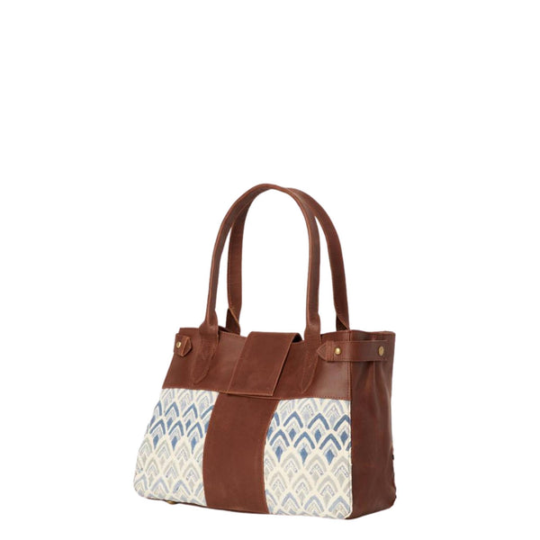 Handbag with hand-blockprinted cotton with blue print and brown leather exterior with paddle handles and expandable side straps
