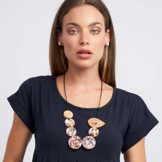 model wearing chunky necklace with resin discs and wooden bird 
